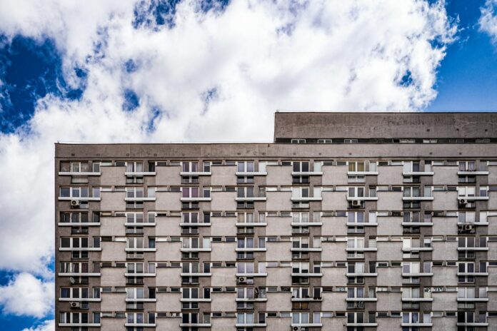 Concrete high-rise apartment building in Warsaw with a clear blue sky.
