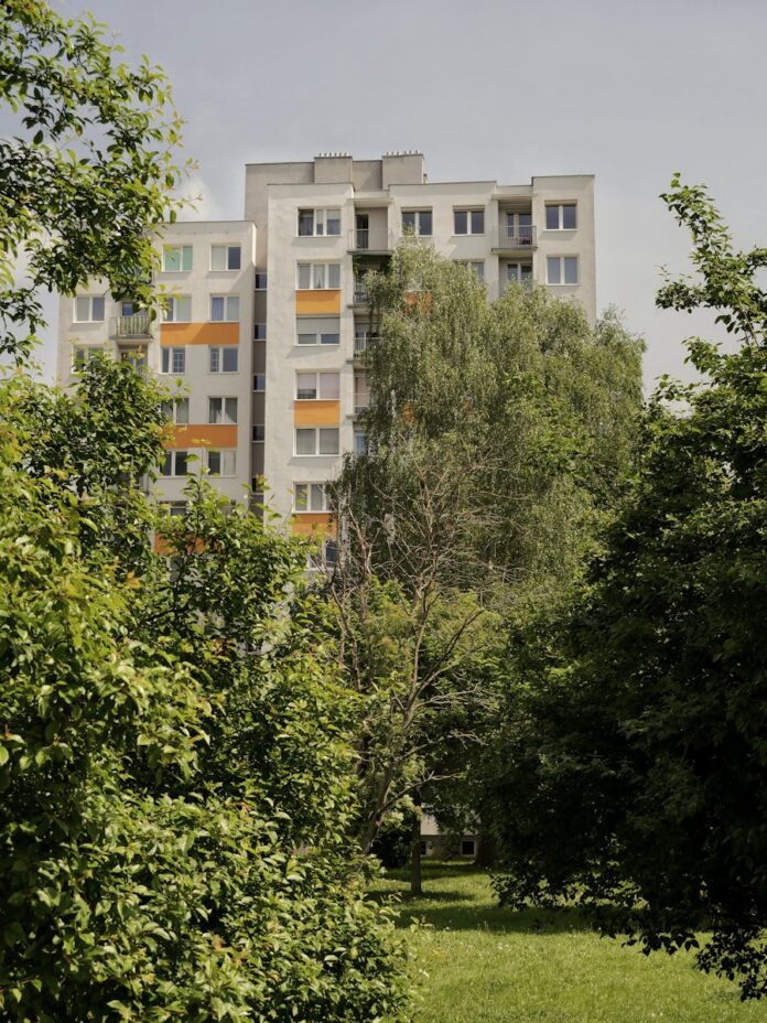 Urban residential building surrounded by lush trees in Zielona Góra, Poland.