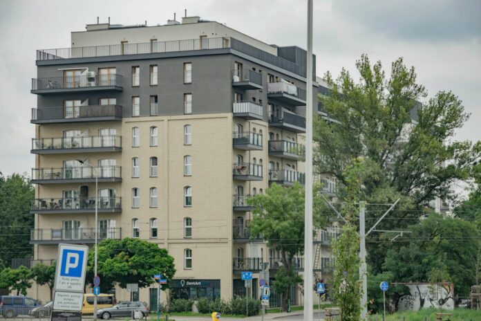 Modern apartment building in Wrocław with balconies and urban surroundings.